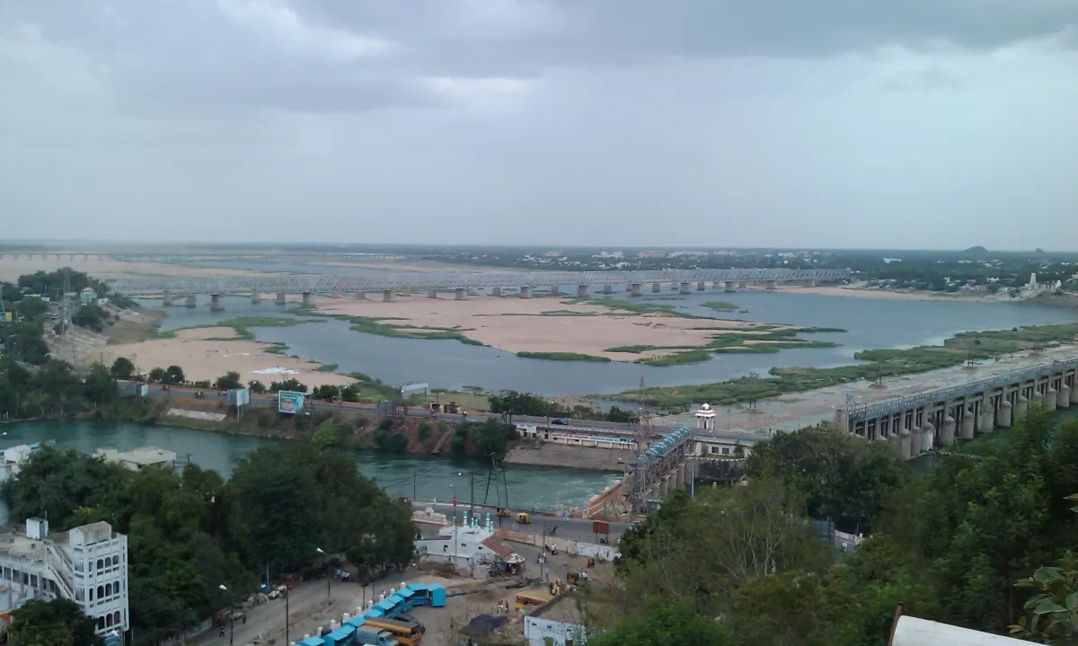 A wide view of the Krishna river and its sandbanks near Vijayawada, with a barrage and buildings in the foreground