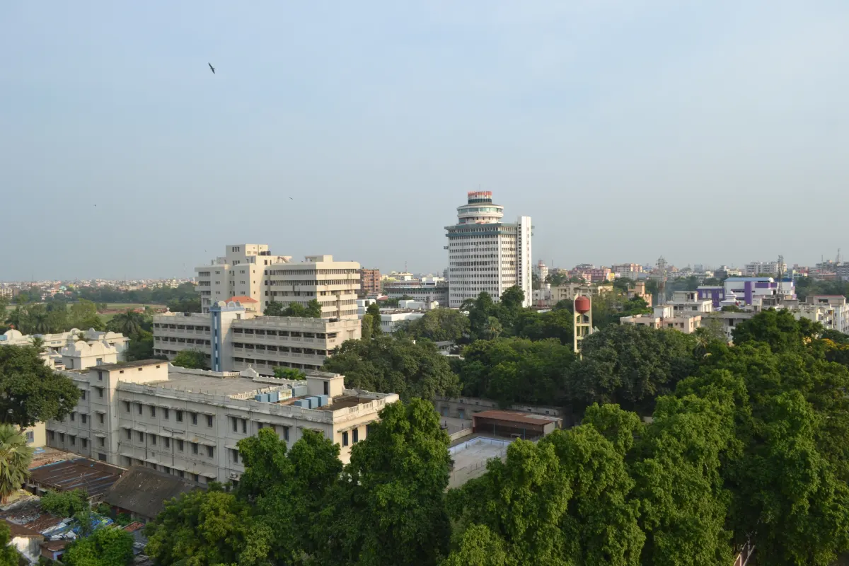 A view of Patna city from above, with white office buildings, a tall round tower and green trees