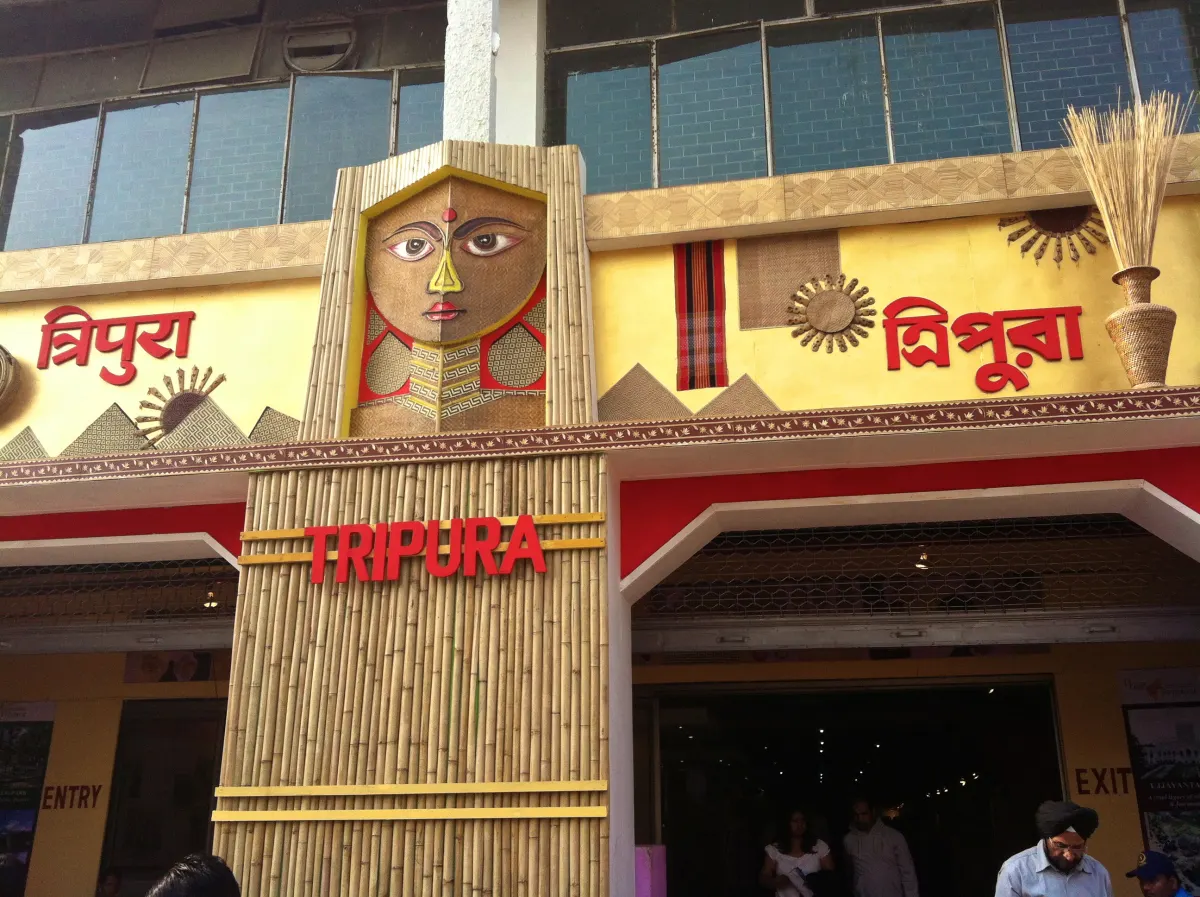 A decorated state pavilion entrance with Tripura written in Bengali and English, at the India International Trade Fair