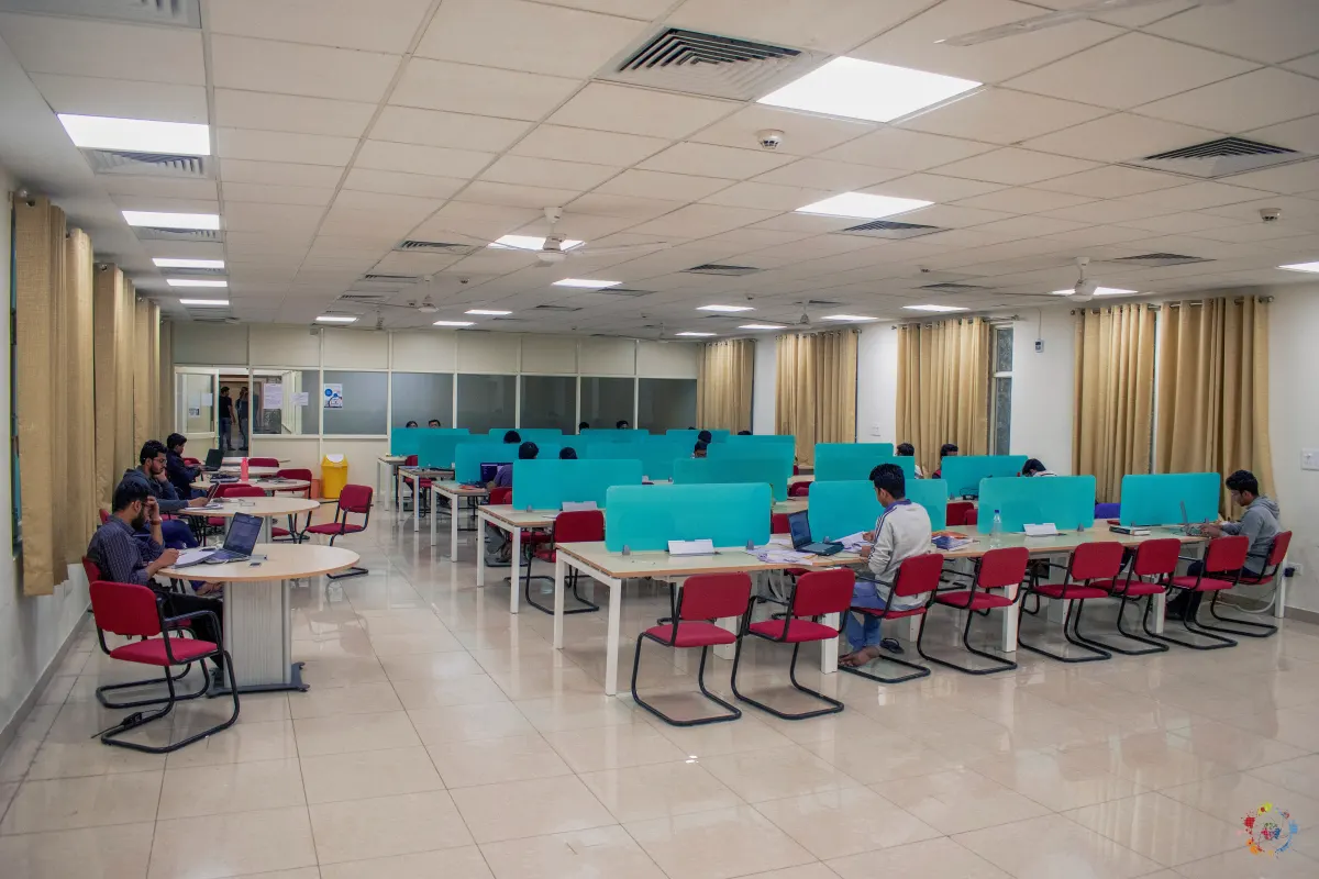 Students studying at desks in a large library reading hall