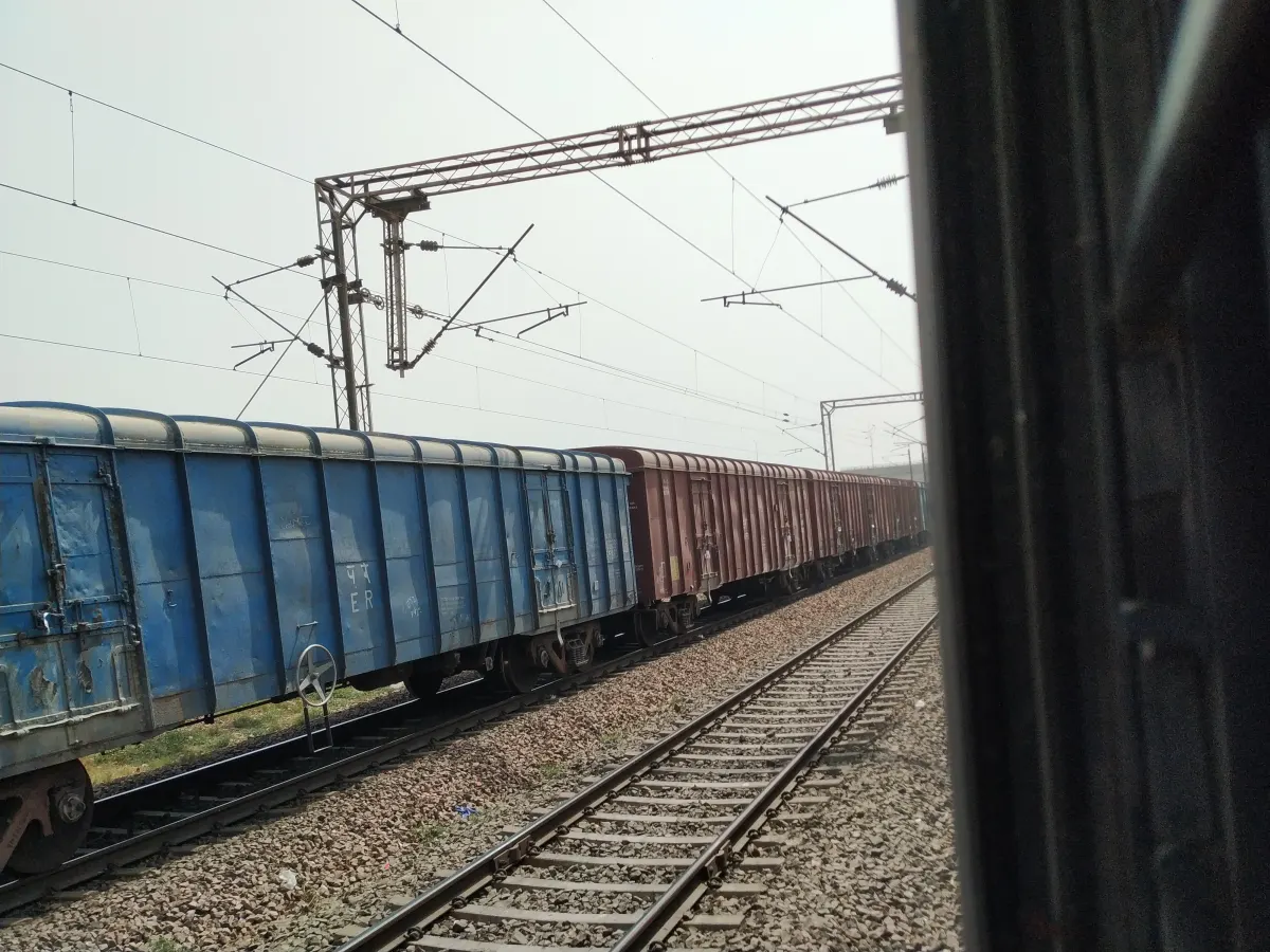 Blue and red wagons of a goods train on an electrified line in India