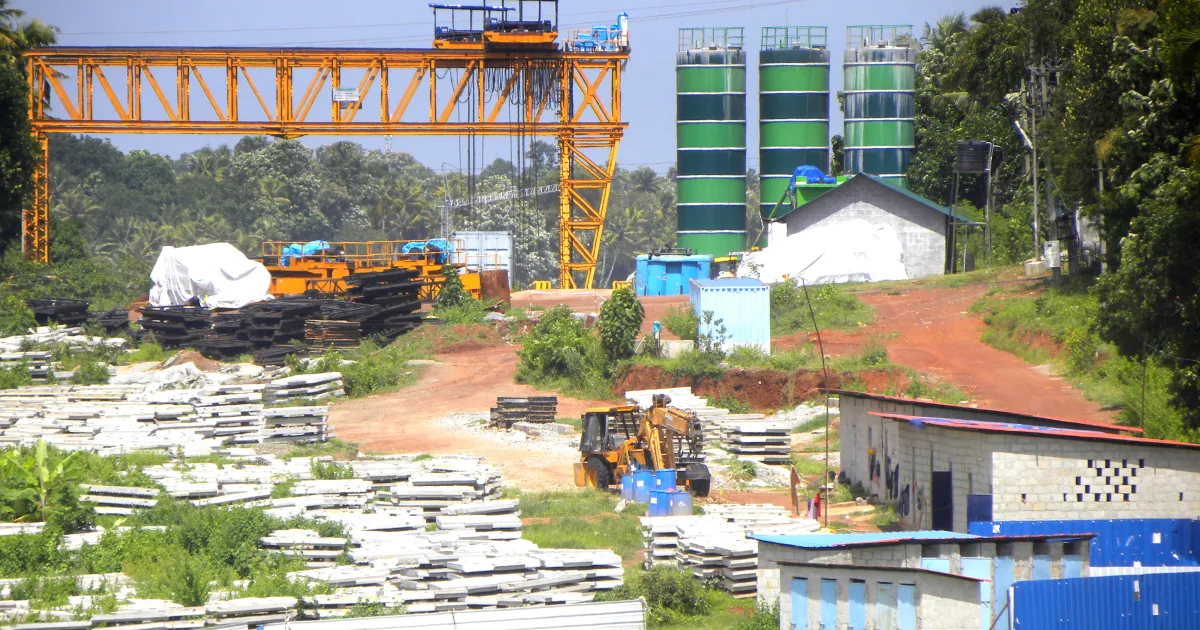 A gantry crane and stacks of precast concrete girders in a casting yard for the Kollam Bypass road project in Kerala