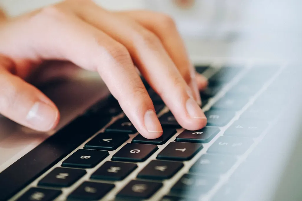 Close-up of hands typing on a computer keyboard