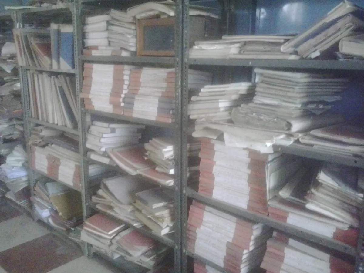 Shelves in an Indian government office packed with paper files tied in bundles