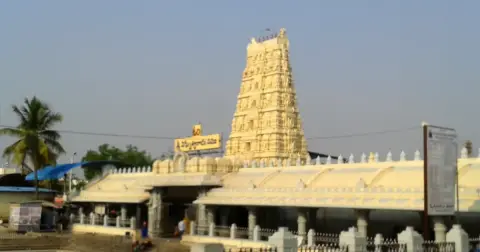The white gopuram and front hall of the Kanipakam temple in Andhra Pradesh, seen from across an open courtyard