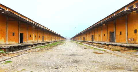 Two long rows of orange warehouse sheds with loading platforms at the CWC Base Depot in Bamanheri, Muzaffarnagar